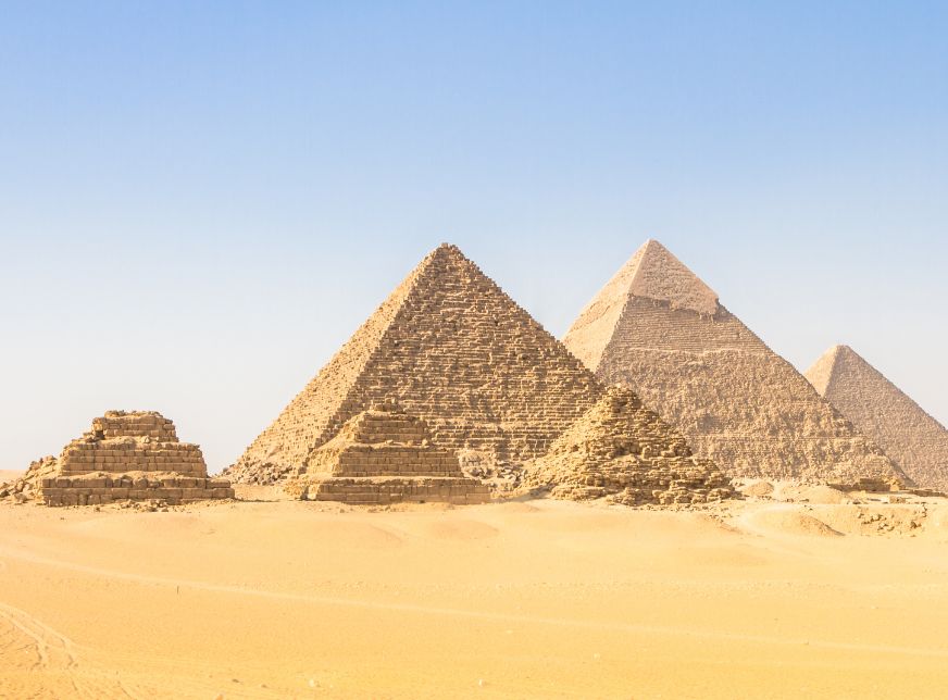 Great Pyramids in Giza Valley in desert with blue sky
