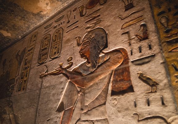 Hieroglyffer omkring udskæring af en gammel gud i en grav i Kongernes Dal, Luxor, Egypten