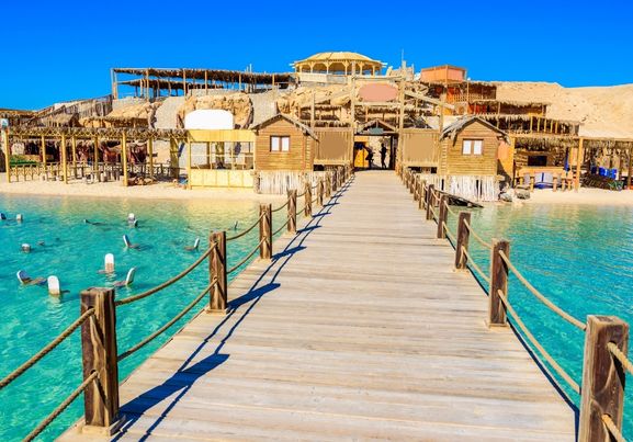 Wooden Pier at Orange Bay Beach with crystal clear azure water and white beach - paradise coastline of Giftun island, Mahmya, Hurghada, Red Sea, Egypt.