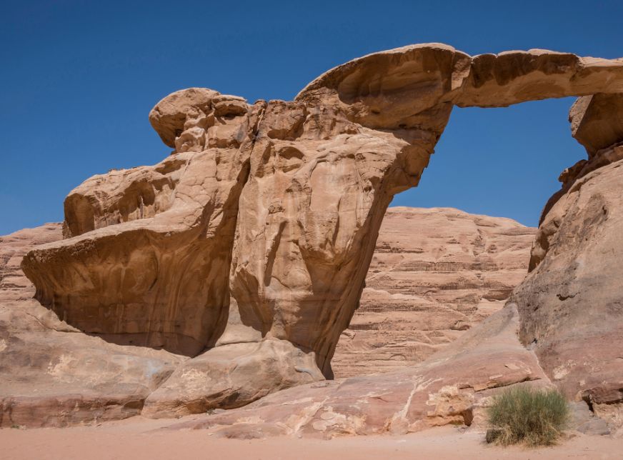 Umm Fruth natural stone arch in Jordan's Wadi Rum desert blue sky
