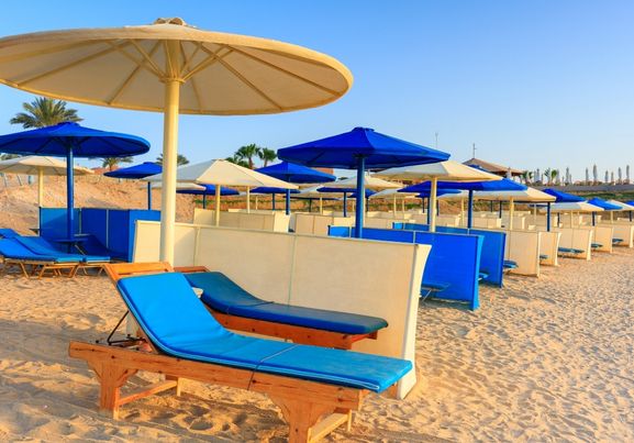 Sun loungers with umbrellas on the beach in Marsa Alam at sunrise Egypt
