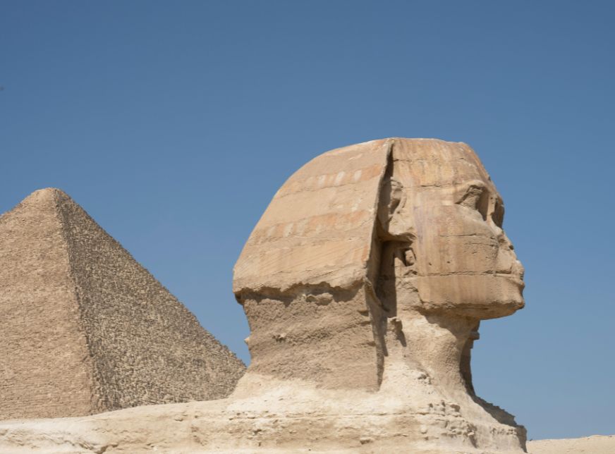 close view of sphinx and pyramids with blue sky giza cairo,egypt