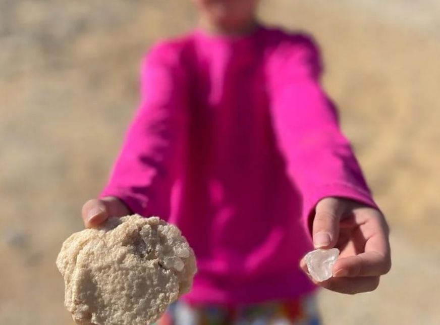 A child holding a piece of crystal from Crystal Mountain in the Bahariya Oasis