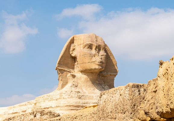 The great ancient Sphinx on a blue background sky with clouds at Giza